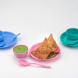 Snack set with a spoon, bowl, and dish on a table.