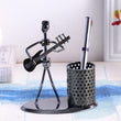 Iron pen stand showpiece of musician playing bass guitar.